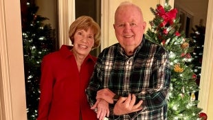 Judy and Gil Gillivan pose in front of a Christmas tree