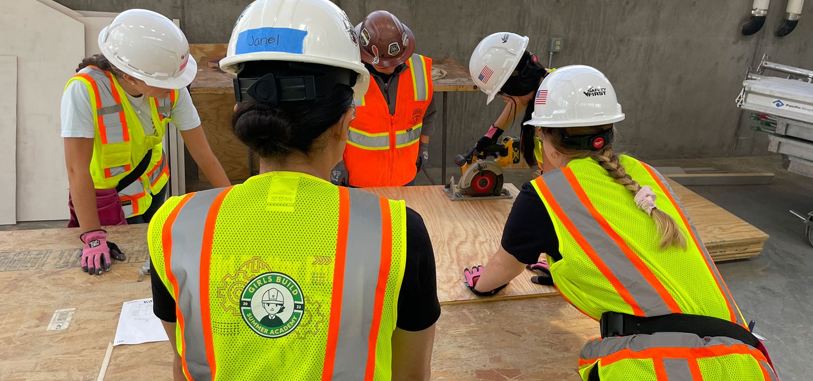 Four attendees of Girls Build Summer Academy work learn to use a power tool