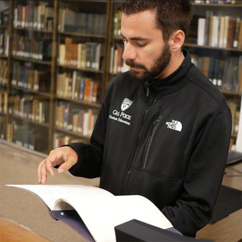 Researcher flipping through a historical document.