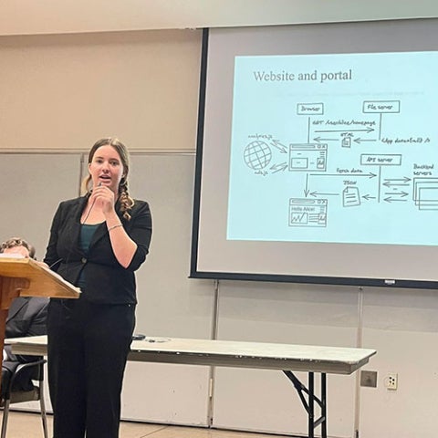 Researcher presents their finding while presenting on a podium.