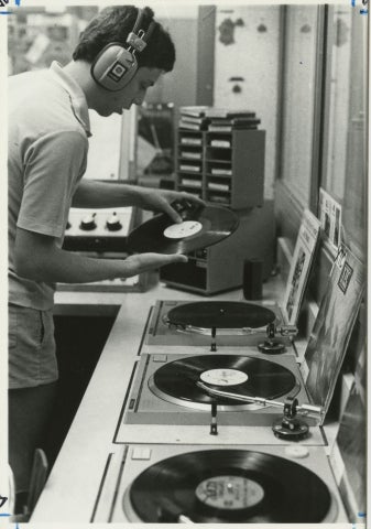 Student inserting a vinyl record into the turntable.