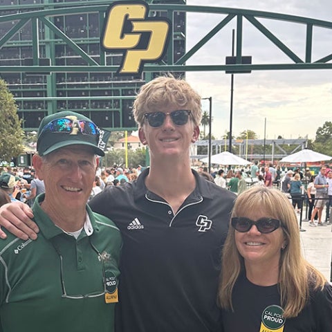 Paul and Katie Winkler and their son pose for a photo at a Cal Poly baseball game