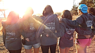 Student leaders pose in front of the sunset