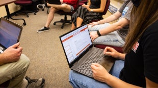 Student using a laptop on her lap