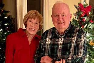 Judy and Gil Gillivan pose in front of a Christmas tree
