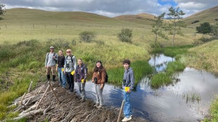 HARCS students conduct fieldwork near a creek