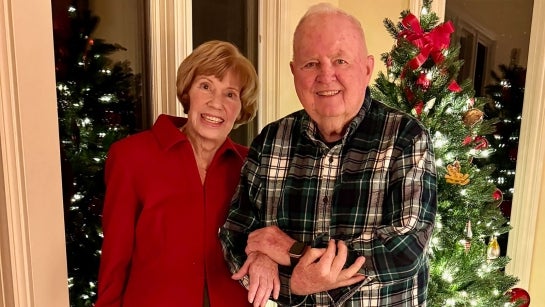 Judy and Gil Gillivan pose in front of a Christmas tree