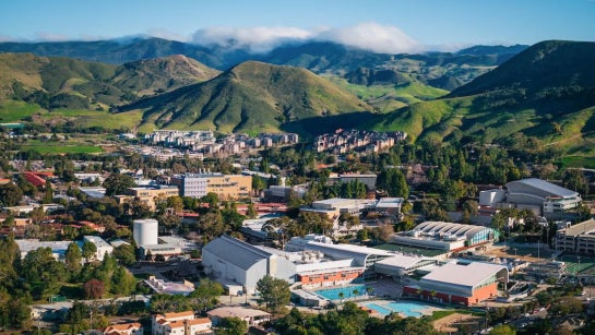 Overhead shot of the Cal Poly campus on a sunny day with green mountains in the background.
