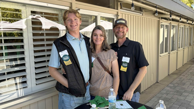 3 people stand and smile