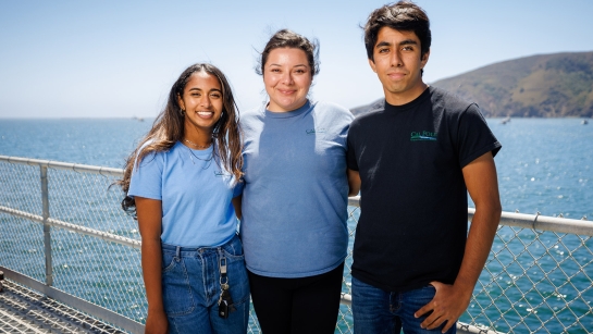 Three Cal Poly students pose smiling on the Cal Poly pier