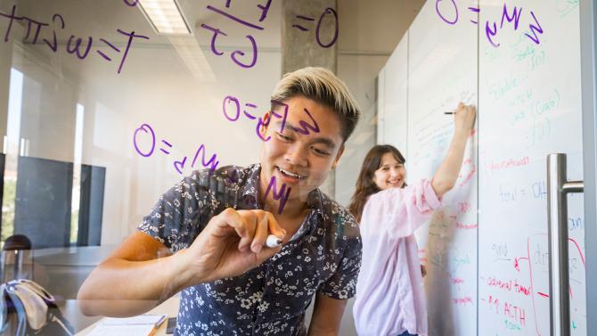 Student writing on window